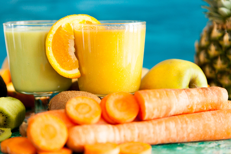 Healthy and raw detox juices next to fruits and vegetablesの写真素材