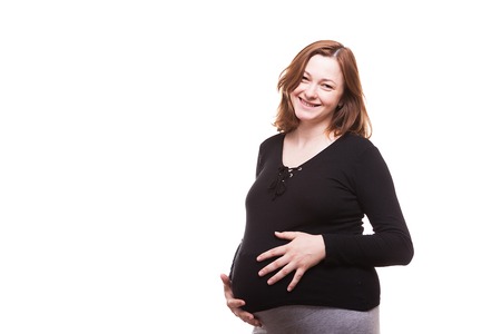 Portrait of beautiful pregnant woman isolated over white background in studioの写真素材