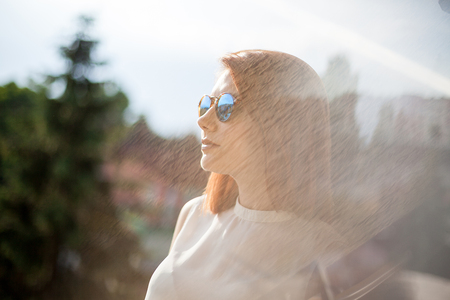 Portrait of gorgeous redhead young woman in summer rays with a reflextionの写真素材