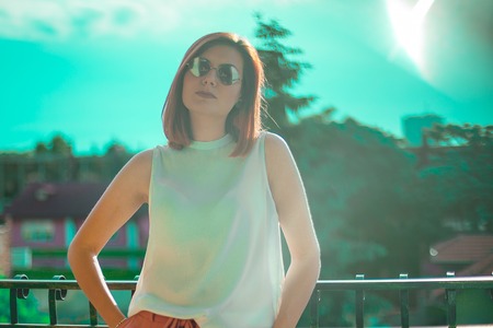 Portrait of beautiful redhair woman wearing glasses. Teal and orange cinematic color grading