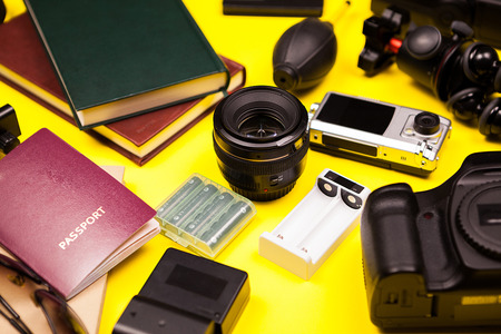 Hipster photographer blogger kit on yellow background made of DSLR camera and other accessoriesの写真素材