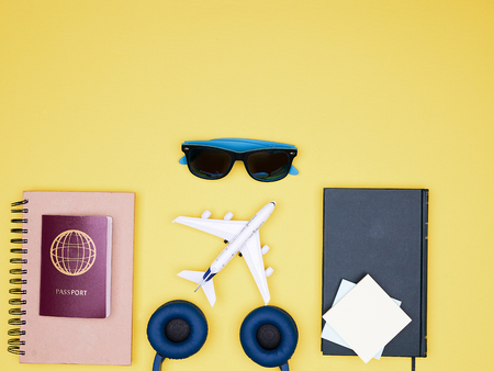 flat lay of traveler kit on yellow background .books, sunglasses and headphonesの写真素材