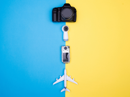Flat lay top view of a plane on yellow background next to camera