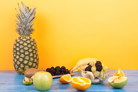 Variety of summer exotic fruits on yellow background. Healthy delicious dessertの写真素材
