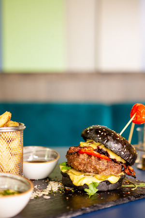 Black burger with beef meat and french fries.Tasty appetizingの写真素材