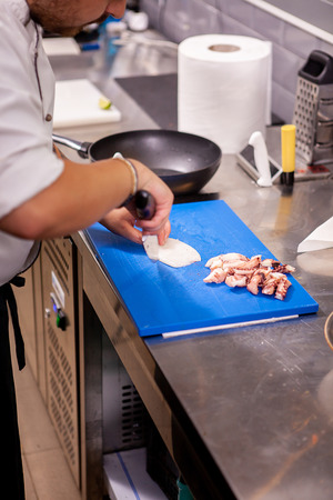 Male cook slicing seafood in restaurant kitchen.Delicious foodの写真素材
