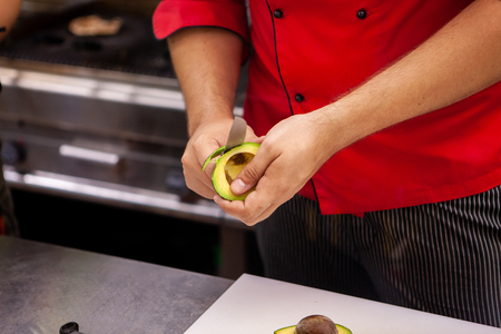 Chef preparing avocado for delicious salade in restaurant kitchenの写真素材