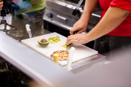 Chef preparing avocado for delicious salade in restaurant kitchenの写真素材
