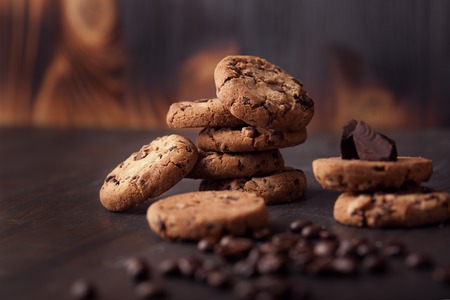 Chocolate chip cookies on old wooden table with coffee beans. Homemade snack.の写真素材
