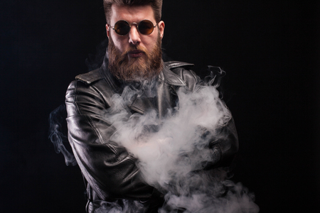 Stylish bearded man with brown sunglasses over black background. Great beard. Serious man.の写真素材