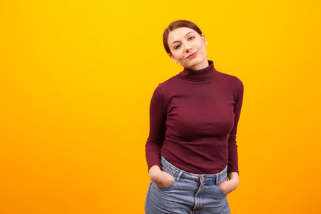 Portrait of caucasian goofy young woman over yellow background. Stylsih young woman. Cheerful girl.の写真素材