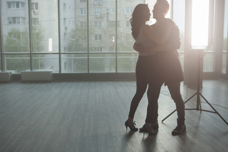 Silhouette of beautiful couple dancing and enjoying the music. Passionate moment. Skillful dancers.の写真素材