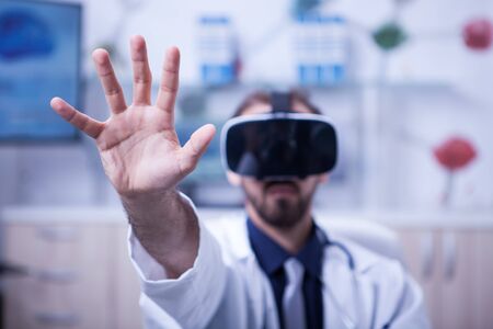 Bearded male doctor working with virtual reality headset. Medicine technology.の写真素材