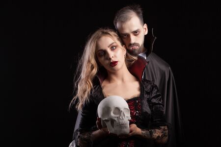 Romantic and imortal vampire couple looking into the camera for halloween carnival.の写真素材
