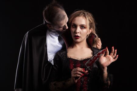 Portrait of a beautiful couple in medieval costumes with vampire style make-up for halloween. Charming vampire woman.の写真素材