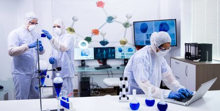 Team of scientist in protection equipment working in a modern research laboratory