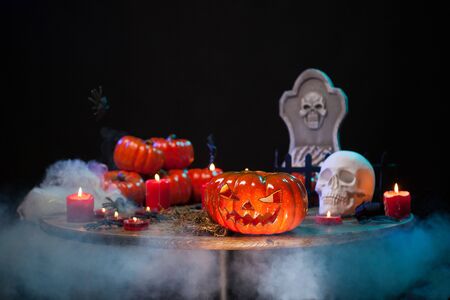 Room with smoke and scary pumpking on a wooden table for halloween celebration. Halloween party. Haunted skull.の写真素材
