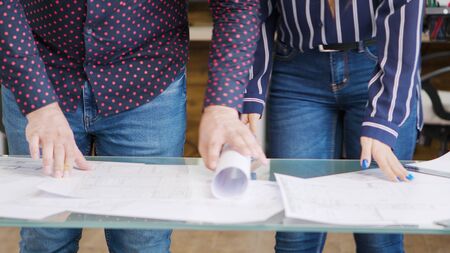 Close up shot of architects table with blueprints on it.