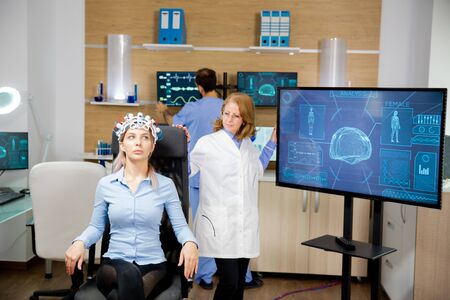 Doctor tracking patient evolution during neurology headset test. Neorological centerの写真素材