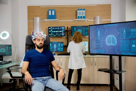 Male patient undergoing a brain scan procedure in the laboratory. Brain waves scanning helmetの写真素材