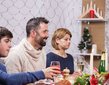 Young fathar and mother with their son at christmas dinner. Traditional christmas decoration. Family celebrating christmas. Beautiful family.の写真素材