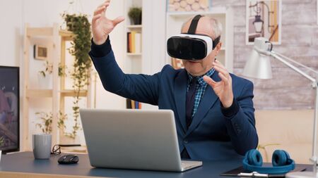 Retired man experiencing virtual reality using vr headset in living room. Cup of coffee on the...