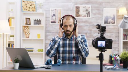 Famous vlogger recording a review and testing headphones. Creative content creator.の写真素材