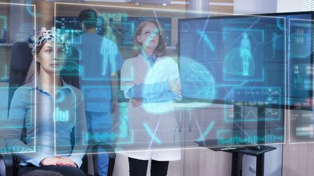 Female scietist looking at virtual hologram interface in front of her eyes and chancing the HUD displays on it with a virtual swipeの写真素材