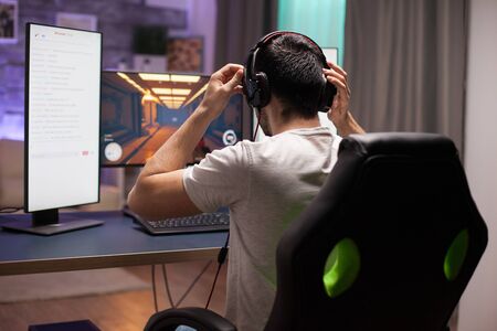 Professional shooter game player putting his headphones on. Competitive esports.の写真素材