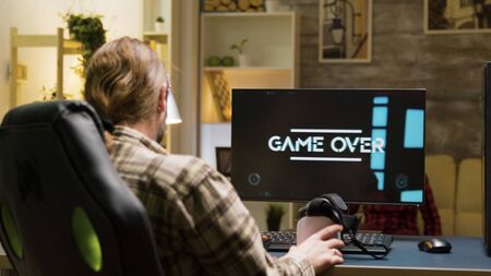 Adult man upset after losing while playing video games using vr headset. Game over for male player.の写真素材