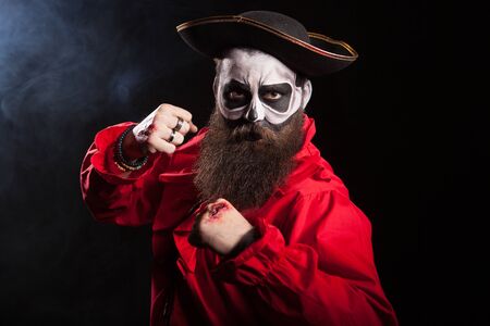 Scary pirate with fists up isolated over black background.Spooky man.の写真素材