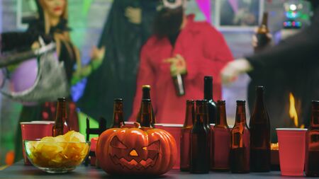 Table with chips and beer for group of people celebrating Halloween at a dance partyの写真素材
