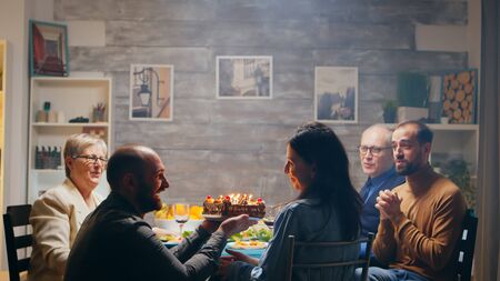 Excited young woman when her husband arrives with delicious cake at her birthday. Slow motion shotの写真素材