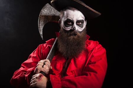 Medieval captain holding an axe over black background. Halloween outfit.の写真素材