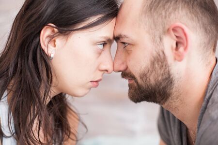 Close up of husband and wife looking into each other eyes in the morning.