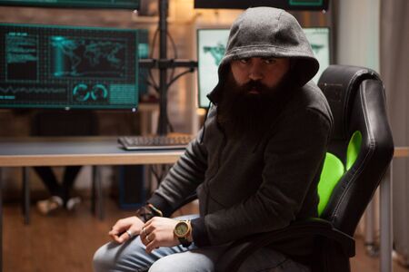Dangerous bearded hacker wearing a hoodie and looking into the camera.の写真素材
