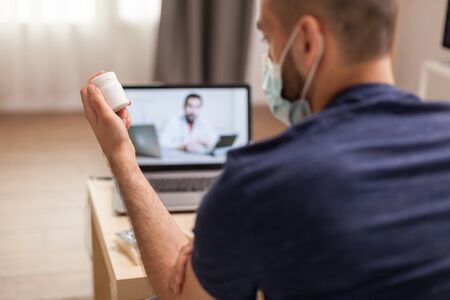 Sick man talking with doctor about prescription on video during quarantine.の写真素材