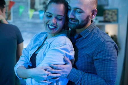 Beautiful young woman having a big smile while dancing with her boyfriend at a party.の写真素材