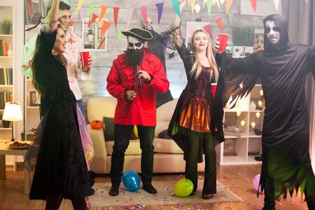 Young man dressed up like a pirate at a halloween party with his friends.の写真素材
