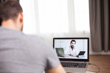 Man having a video conference with his doctor during self isolation.