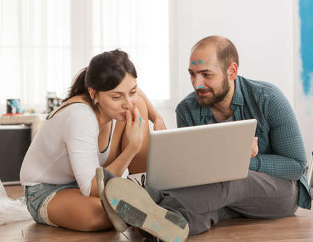 Married couple buying furniture online for their new apartment. Apartment redecoration and home...