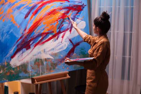 Successful artist working peacefully on masterpiece painting. Modern artwork paint on canvas, creative, contemporary and successful fine art artist drawing masterpieceの写真素材