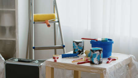 Tools for home renovation. Paint cans, brush, roller. Home during renovation, decoration and painting. Interior apartment improvement maintenance. Roller, ladder for house repairの写真素材