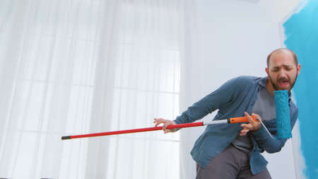 Dancing with roller brush during home repairing. Apartment redecoration and home construction while renovating and improving. Repair and decorating.の写真素材