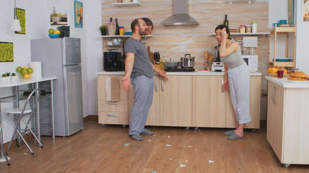Angry wife smashing dish in an argument with husband.の写真素材