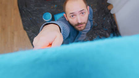 Painting wall with roller brush by handyman during home renovation.の写真素材