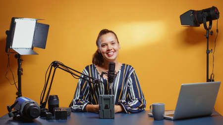 Influencer talking about professional video equipment in her studio set. Professional videography gear review by content creator new media star influencer on social media.の写真素材