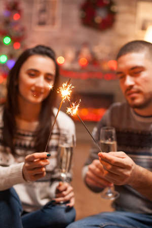 Glowing hand fireworks holded by young couple on christmas day.の写真素材