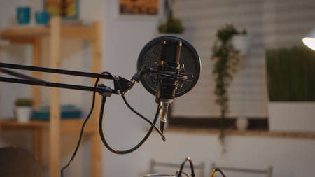 Zooming on professional microphone in vlogger home studio and neon light in the background. Influencer recording social media content with production microphone. Digital web internet streaming stationの写真素材
