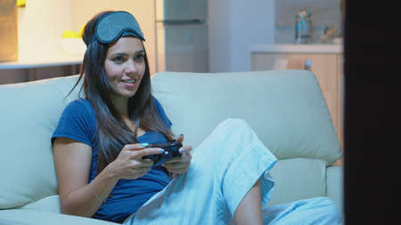 Gamer using joystick playing video games on console sitting on couch in living room. Excited...